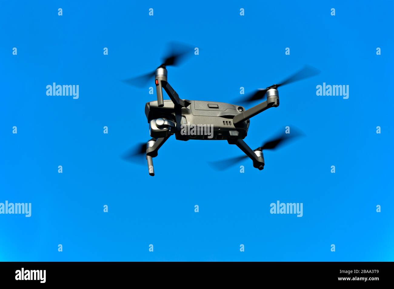 Drone in volo contro il cielo blu Foto Stock
