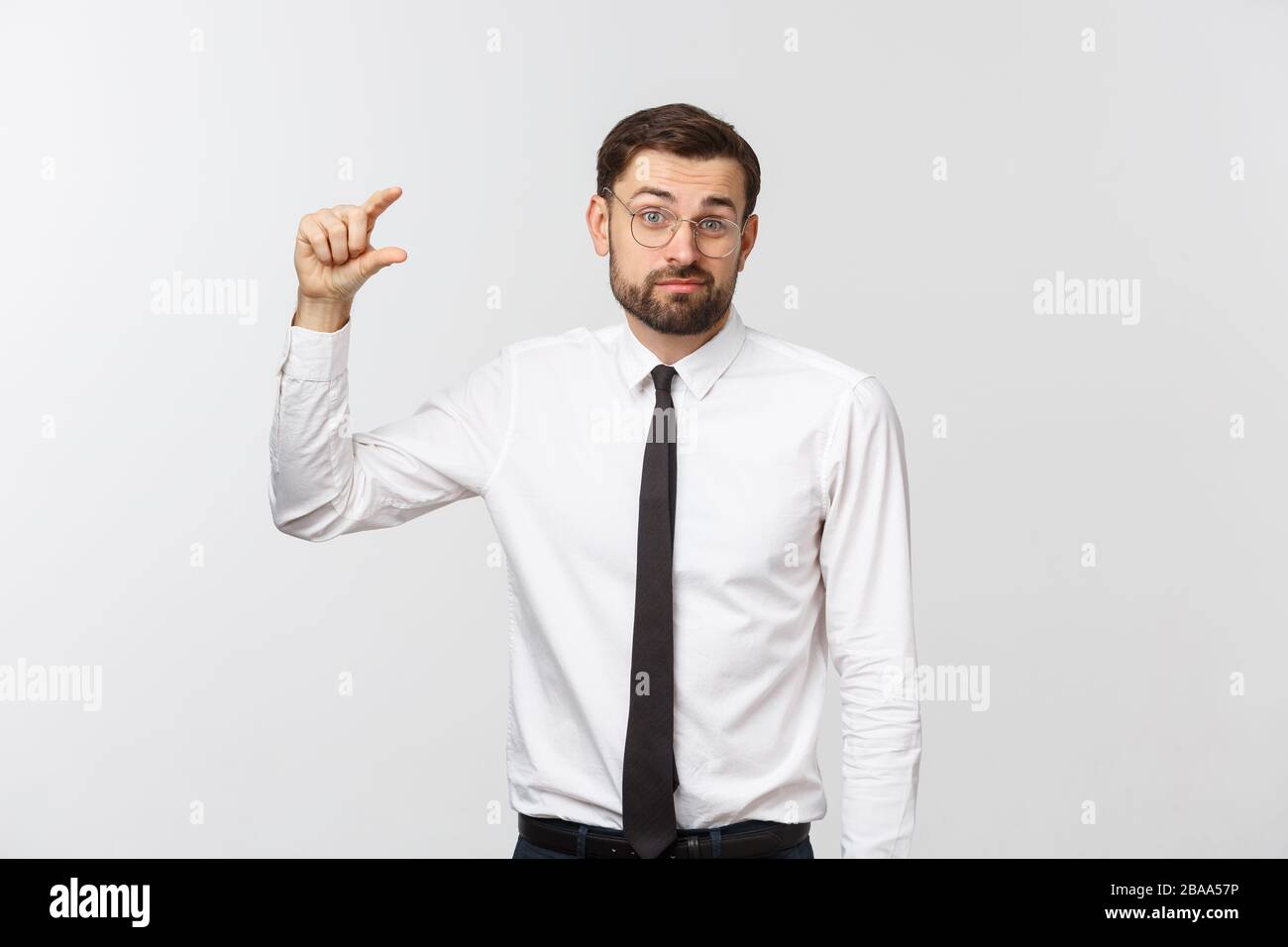 uomo d'affari che rende le sue dita di piccole dimensioni. emozioni, espressioni facciali, sentimenti, linguaggio del corpo, segni. immagine su uno sfondo bianco studio Foto Stock