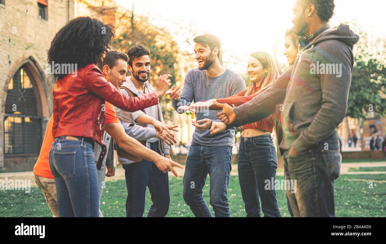 Gruppo di persone multirazziali che giocano al gioco Rock Paper Scissors. Studenti di cultura diversa divertirsi all'aperto Foto Stock