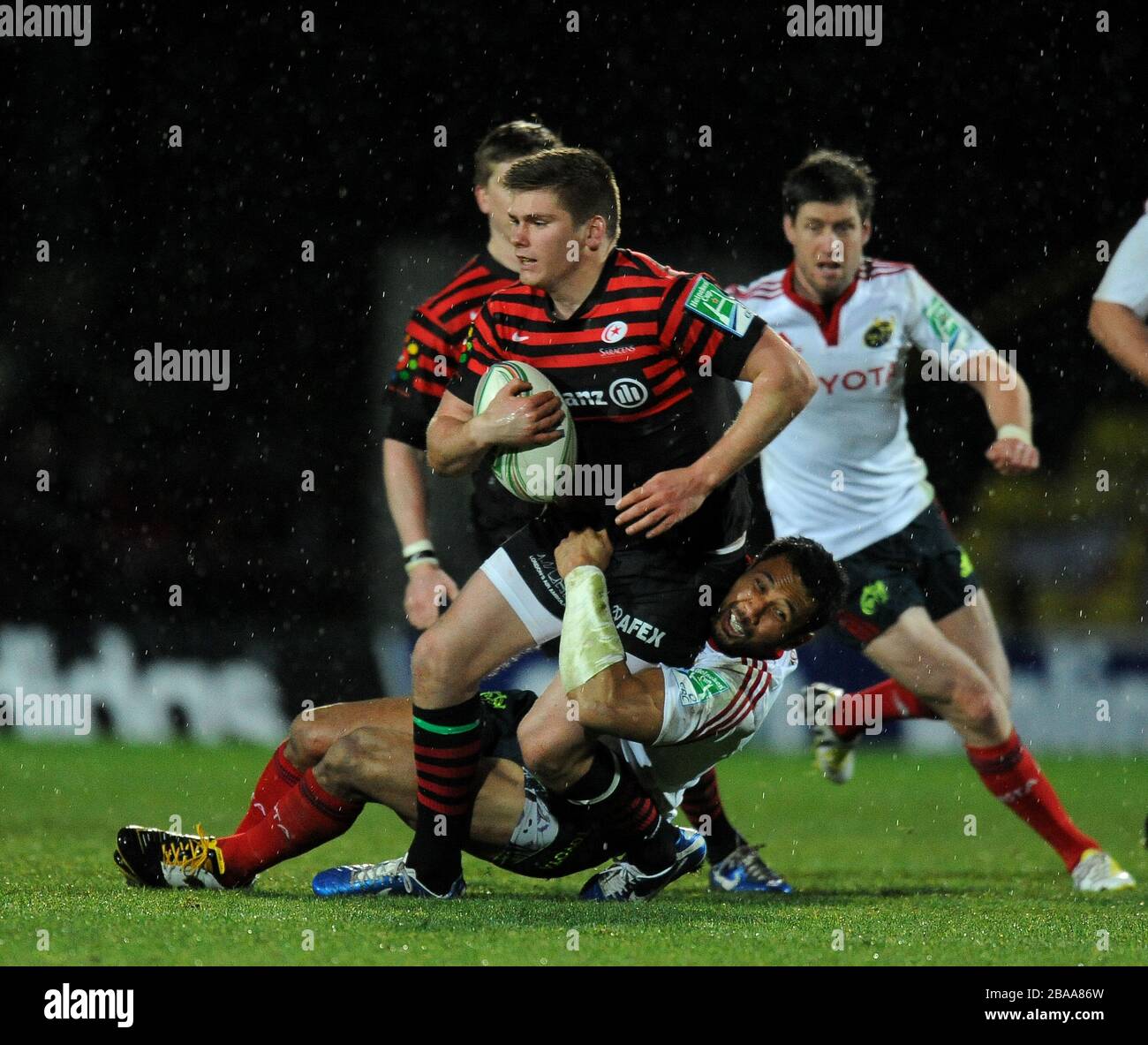 Owen Farrell di Saracens affrontato da Casey Laulala di munsters Foto Stock