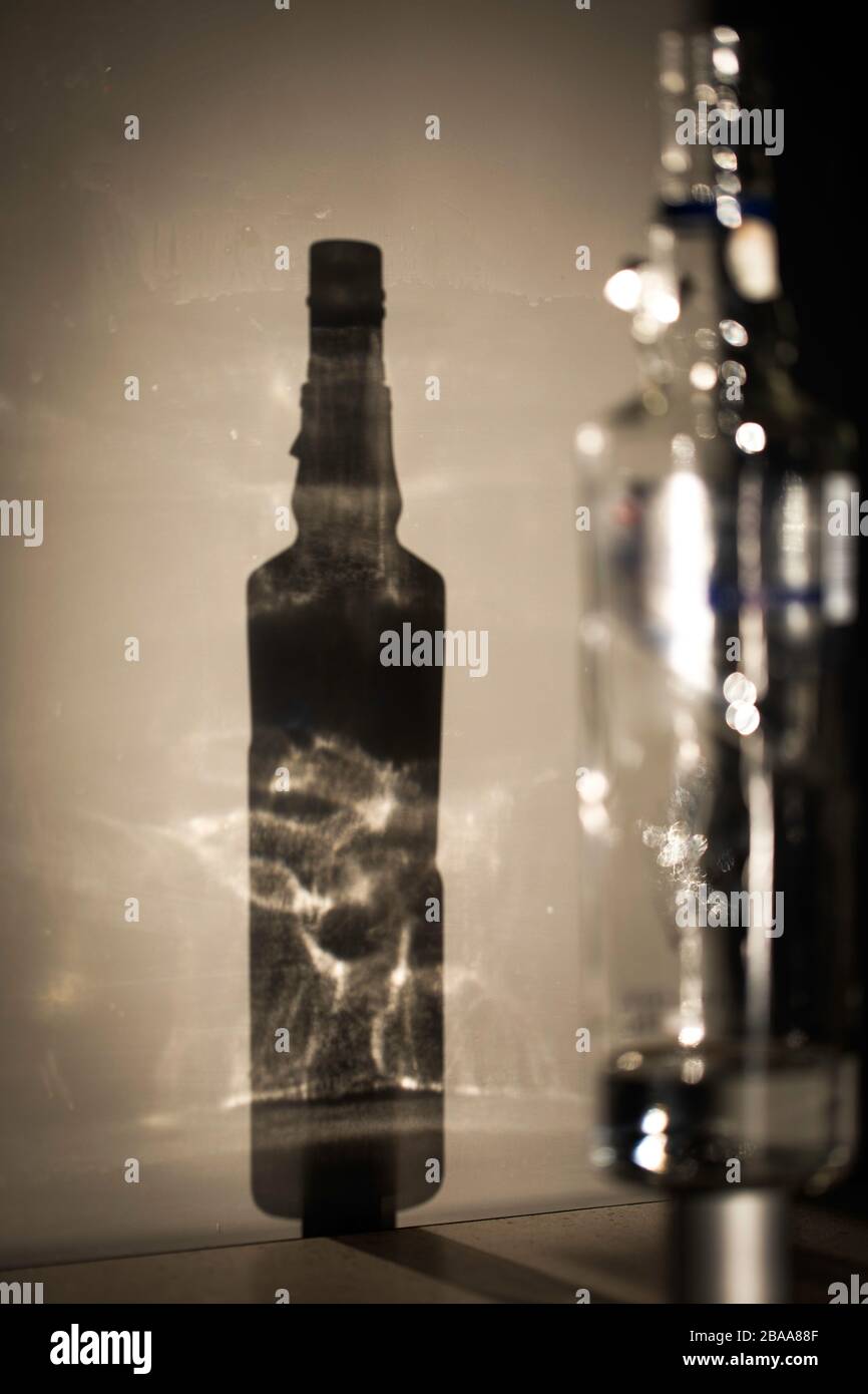 Ombra di una bottiglia di vodka, giochi di luce e riflessi. Foto Stock