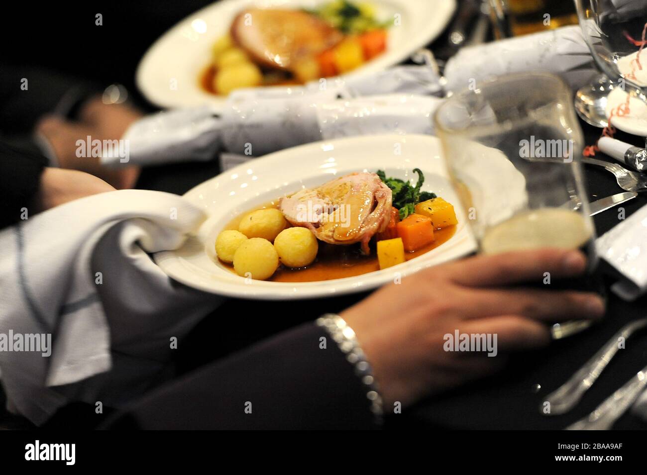Il personale d'attesa consegna il cibo ai tavoli degli ospiti Foto Stock