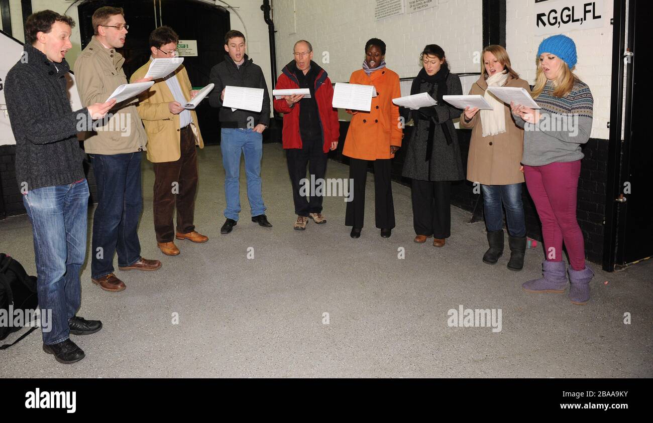 Le canzoni sono cantate da un gruppo di cantanti carol durante il Natale al Cottage Foto Stock