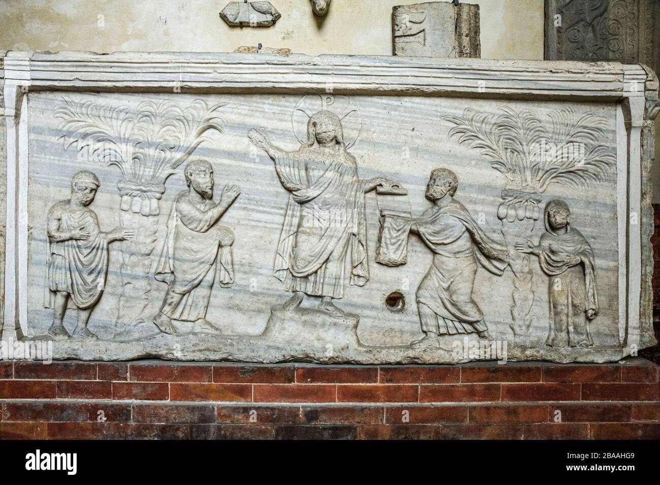 Italia - Emilia Romagna - Ravenna - Museo Nazionale - sarcofago della Traditio Legis in marmo proconnesiano ispirato, sia per il motivo trattato che per la struttura architettonica, da modelli di Costantinopoli. Il sarcofago, privo della copertina originale e di uno dei due lati lunghi, può essere datato al primo quarto del V secolo. Sul fronte la composizione è dominata dalla figura di Cristo con nimbus monogramma e ricoperta di tunica e pallio. Alla destra di Cristo c'è l'apostolo Paolo che eleva il braccio destro in giubilazione. Foto Stock