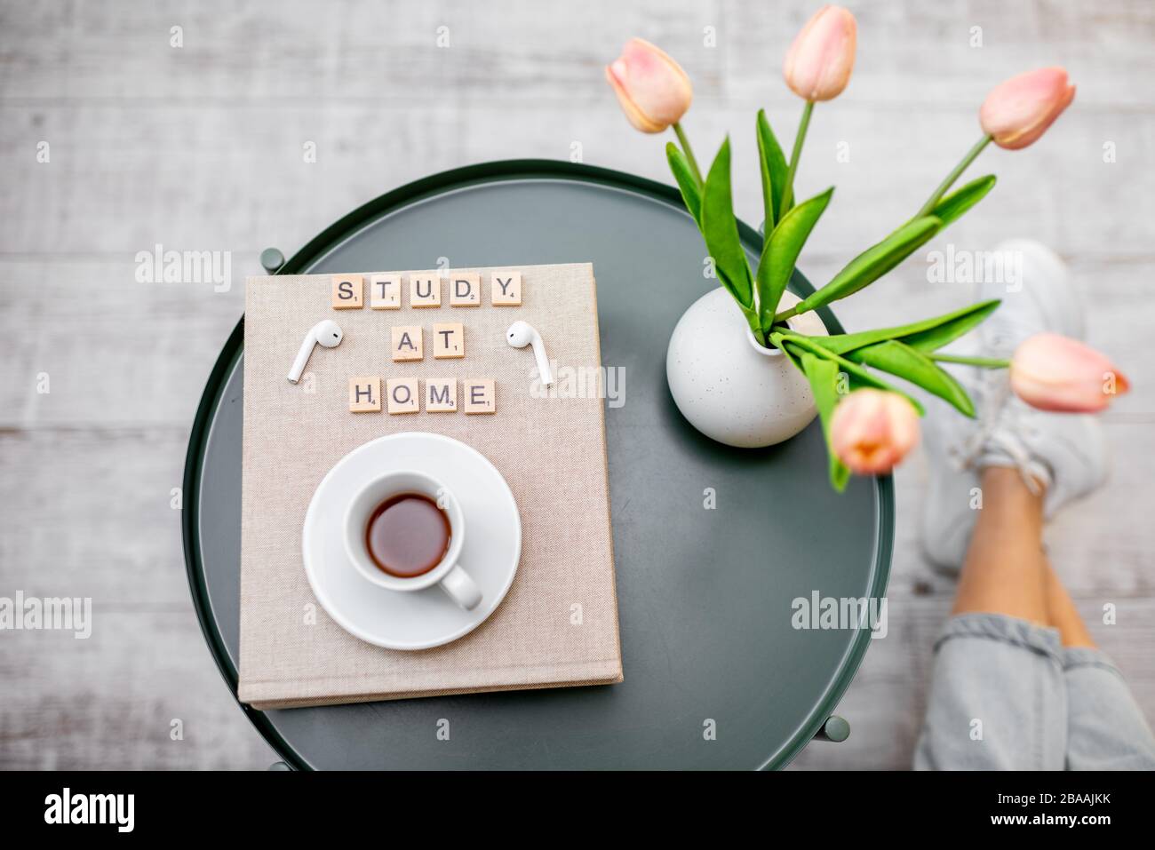 Fiori, libri e una tazza di caffè su un tavolo rotondo all'interno, vista dall'alto. Studio a casa e accogliente atmosfera di casa concetto Foto Stock