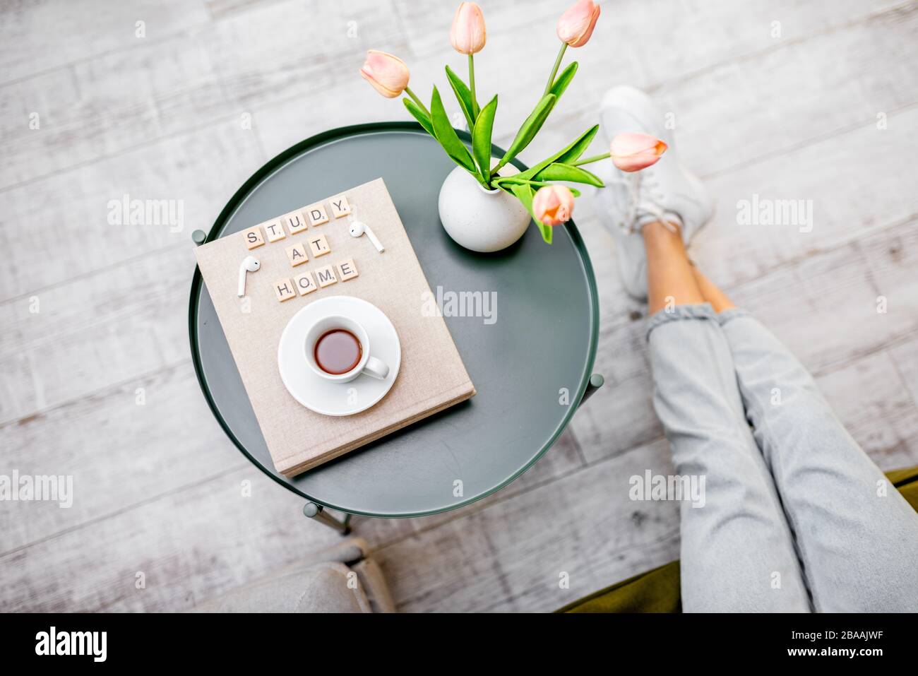 Fiori, libri e una tazza di caffè su un tavolo rotondo all'interno, vista dall'alto. Studio a casa e accogliente atmosfera di casa concetto Foto Stock