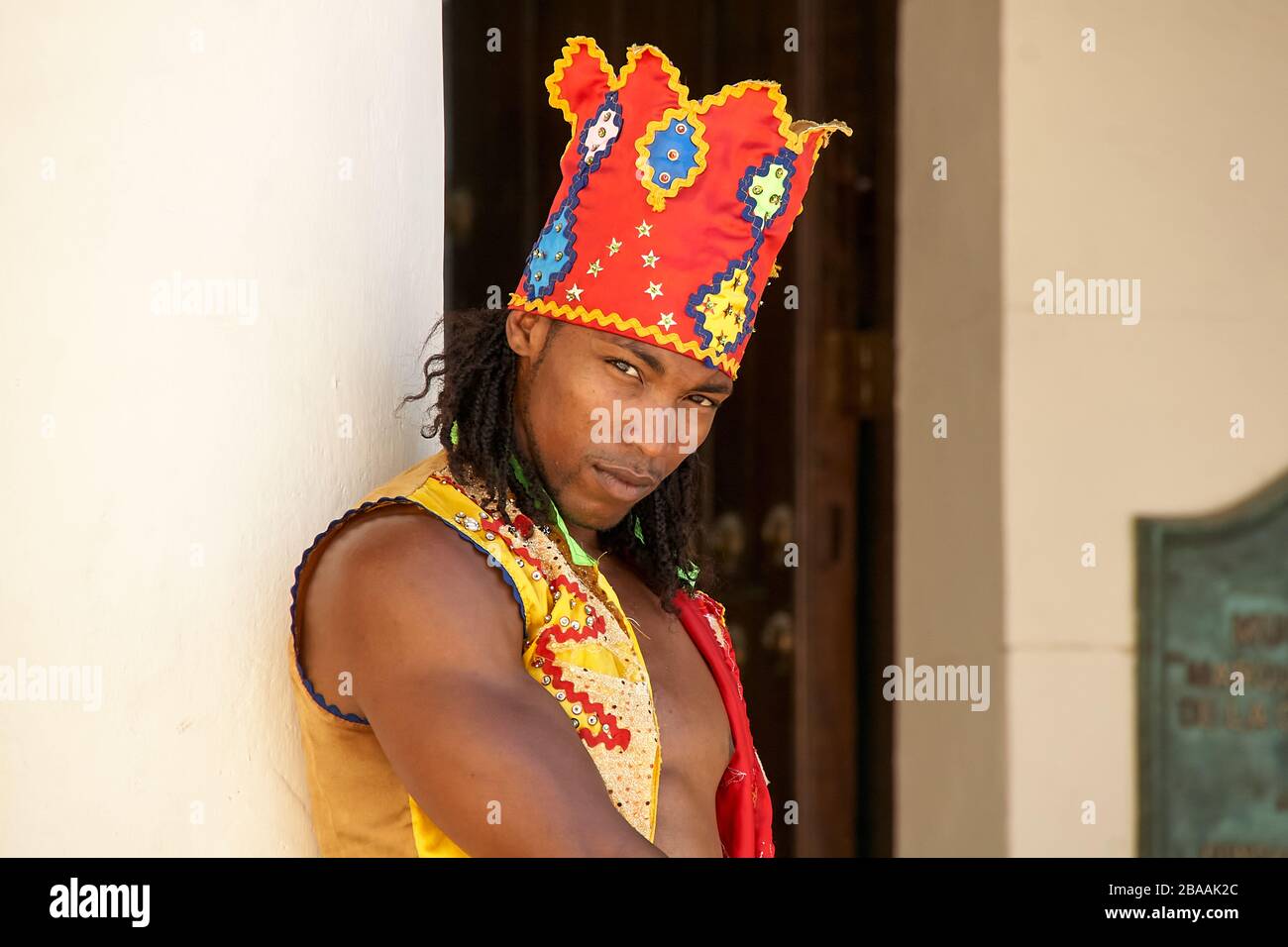 Afrocuban stills ballerino Street performer in headdress colorato e waistcoat in Plaza Vieja, Havana Foto Stock