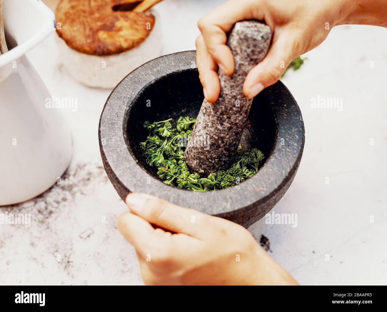 Produzione di sale di erbe di prezzemolo in un mortaio Foto Stock