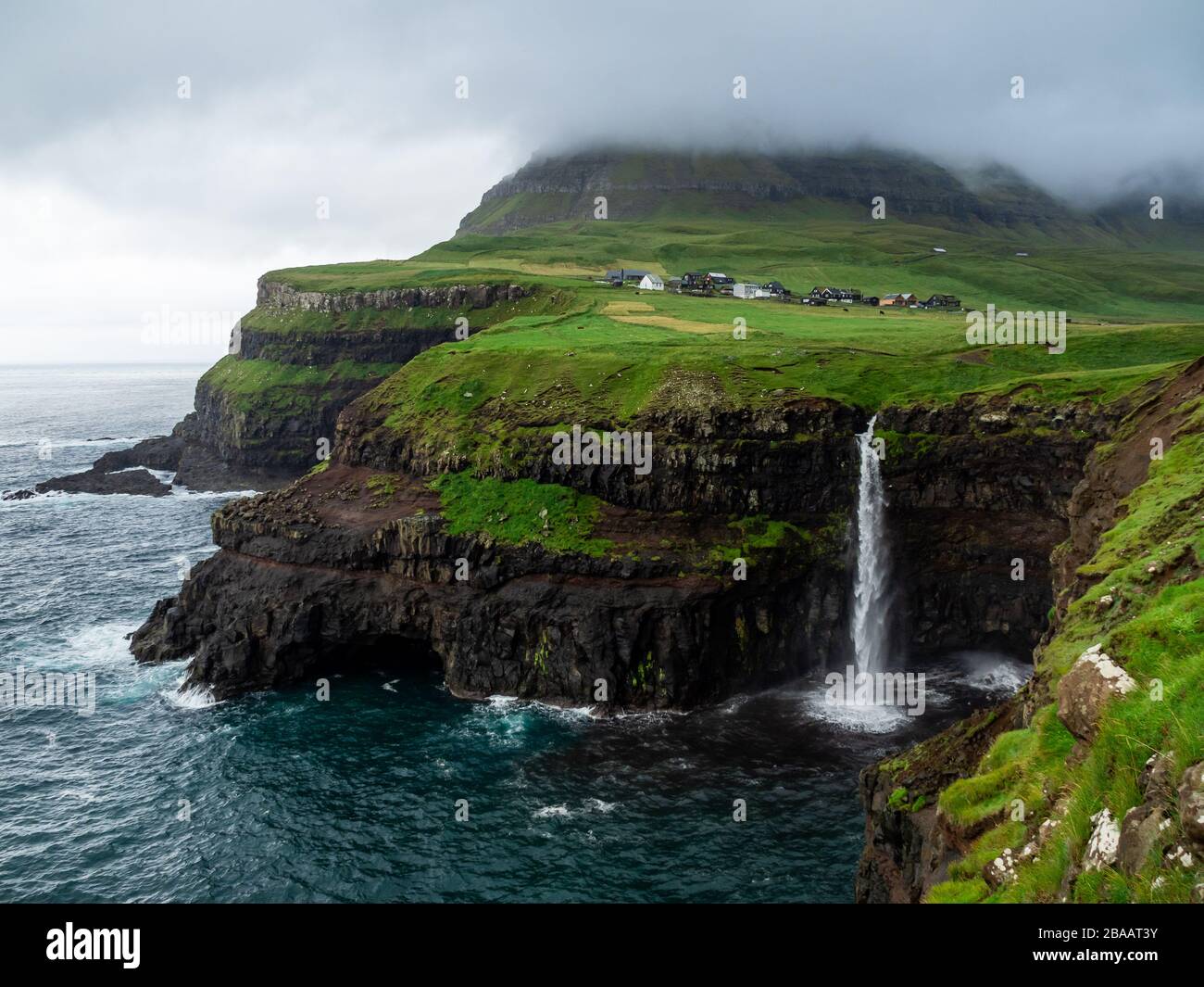 Isole Faroe. La cascata di Múlafossur e il villaggio di Gasadalur sulla cascata. Esposizione lunga. Paesaggio frizzante. Foto Stock