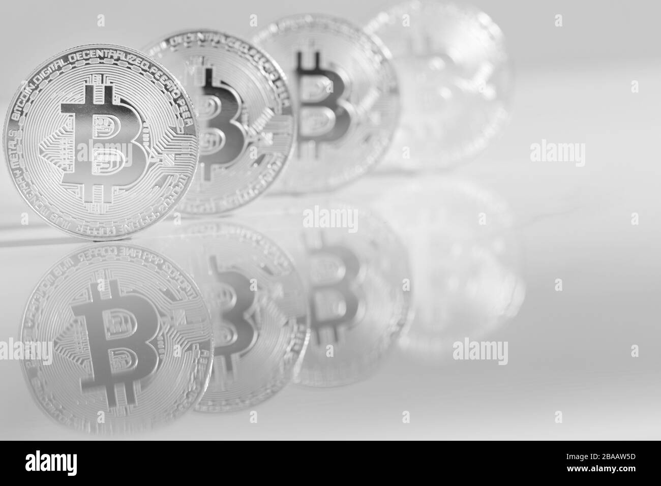 Monete d'argento sulla scrivania in marmo riflettente, primo piano. Denaro virtuale di criptovaluta. Exchange, anonimo. Bitcoin è una valuta di cassa web open source Foto Stock