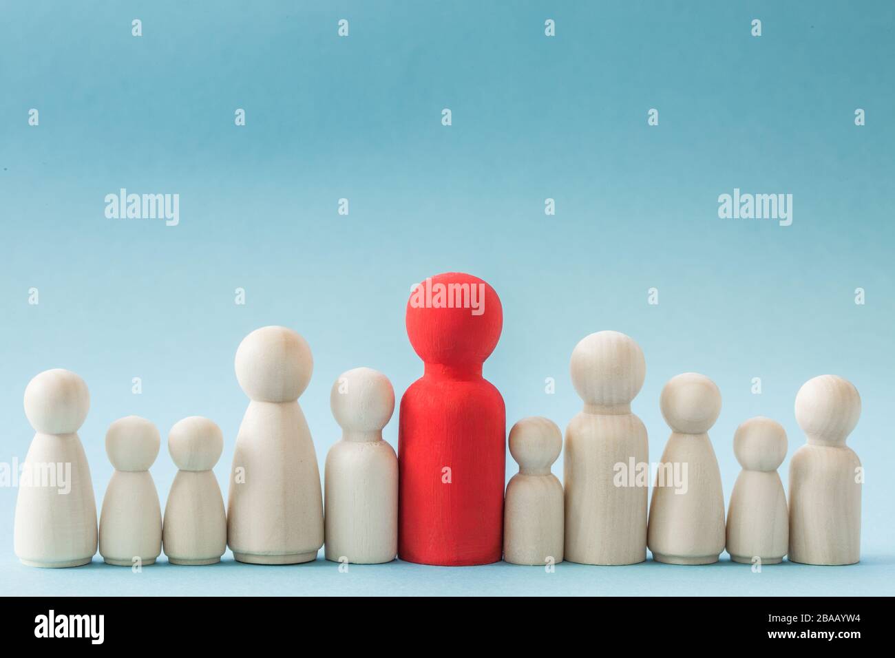 Un concetto di una fila di persone generiche che rappresentano un grande gruppo familiare con una sola testa o un genitore e molti figli con spazio di copia Foto Stock