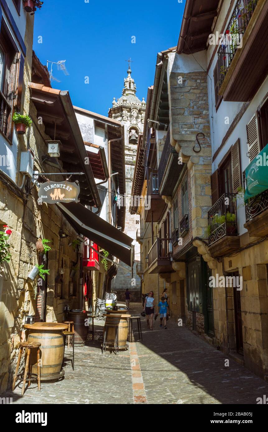 Hondarribia, Gipuzkoa, Paesi Baschi, Spagna - 18 luglio 2019 : vicolo nell'Alde Zaharra o città vecchia murata con il campanile barocco del Foto Stock