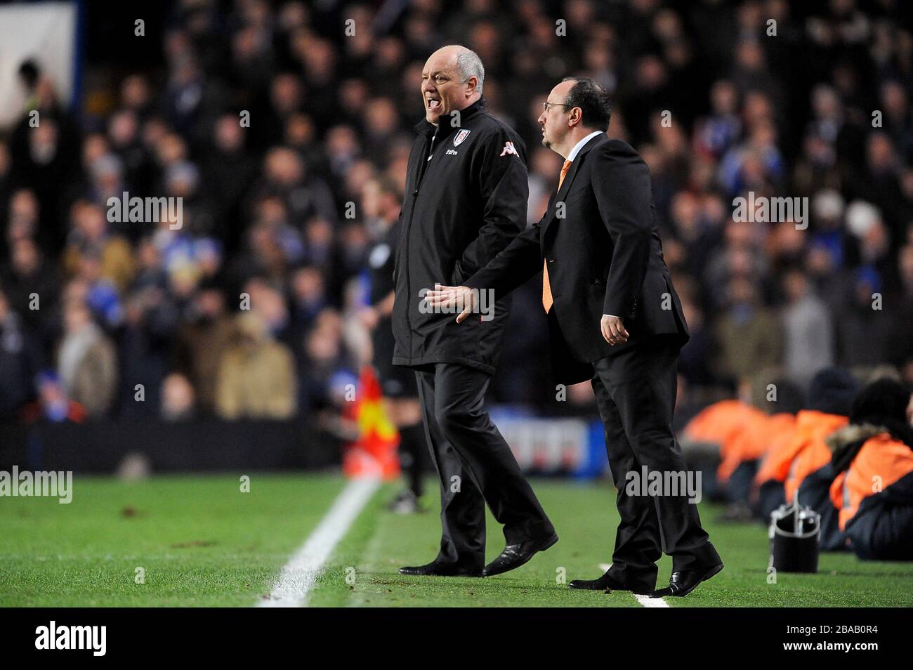 Il manager di Chelsea Rafael Benitez (a destra) e il manager di Fulham Martin Jol (a sinistra) gitano le istruzioni ai loro team sulla linea di contatto Foto Stock