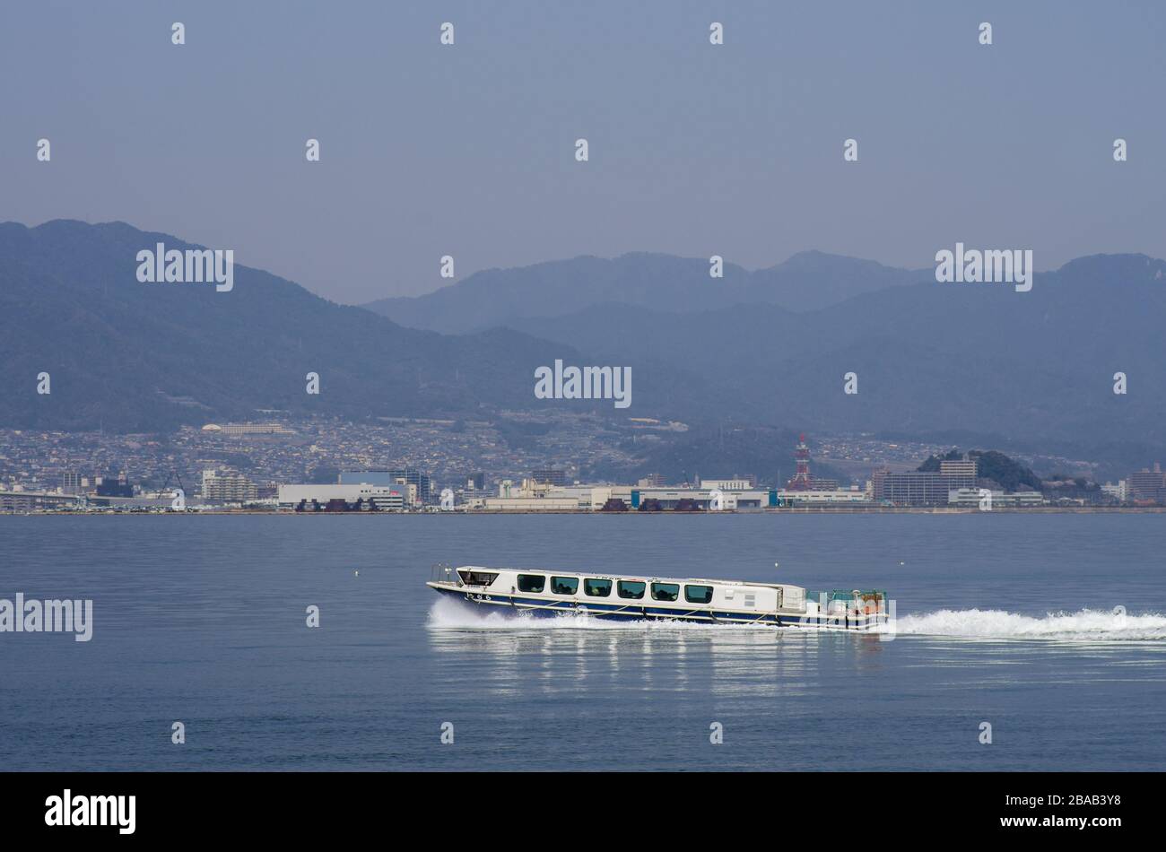 Traghetto Aqua Net che parte dal Peace Memorial Park fino a Miyajima con Hiroshima sullo sfondo, Hiroshima, Giappone Foto Stock