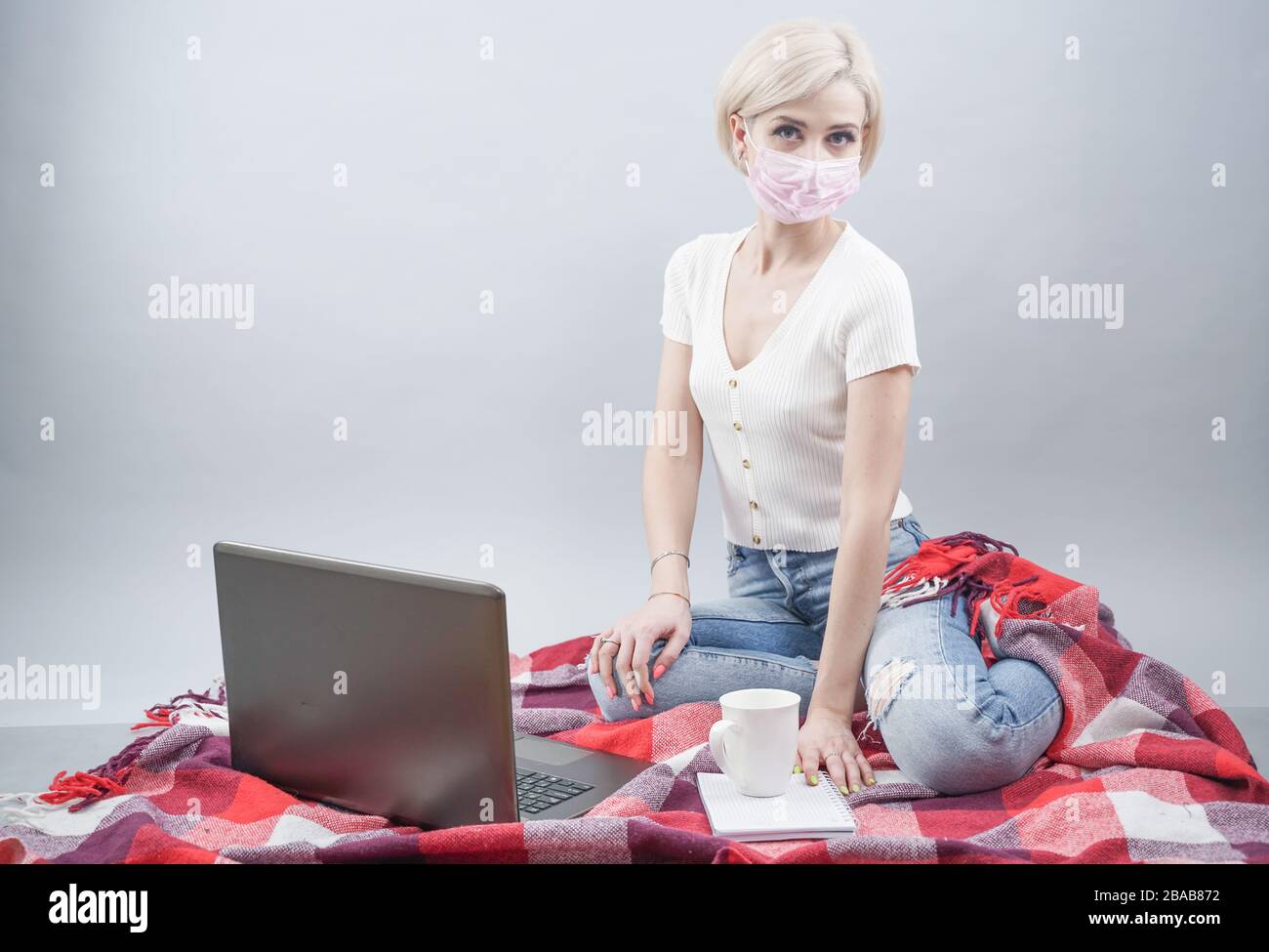Coronavirus. Donna in ufficio a casa malata con maschera medica per il virus corona. Ragazza indossare maschere per proteggere e prendersi cura della salute. Home lavorare con compu Foto Stock