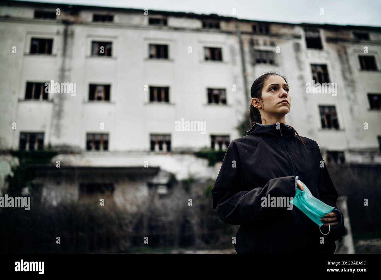 Spaventata donna devastata in possesso di mask.Activities protettivo in tempo di epidemic/pandemic.Panic e paura di infection.Life in area contaminata.Actions Foto Stock