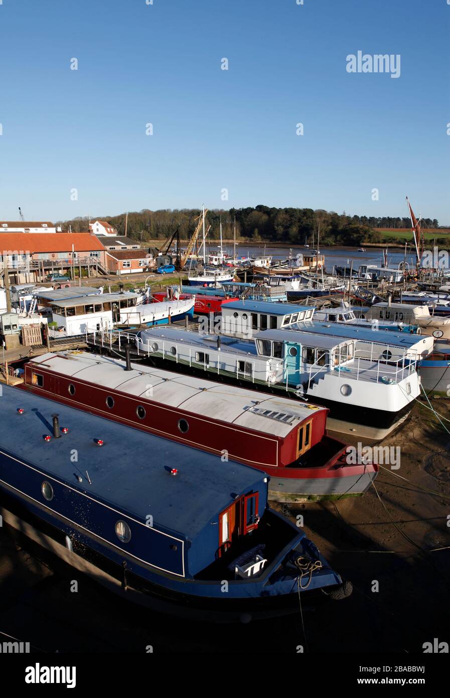 Chiatte e una varietà di vivere a bordo di case galleggianti ormeggiate al Ferry Quay, fiume Deben, Woodbridge, Suffolk, Inghilterra, Regno Unito Foto Stock