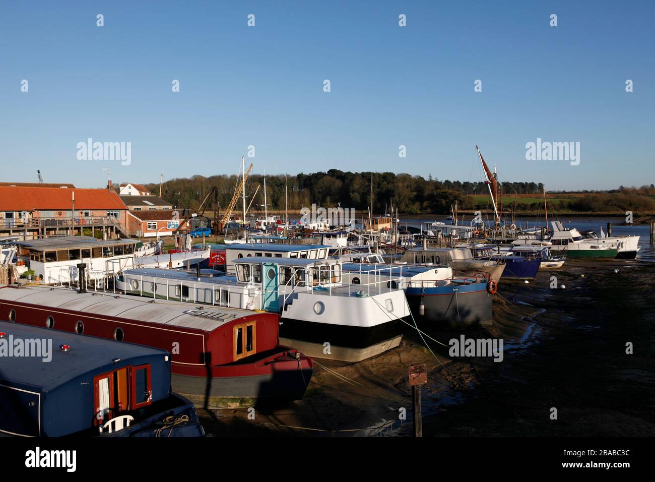 Chiatte e una varietà di vivere a bordo di case galleggianti ormeggiate al Ferry Quay, fiume Deben, Woodbridge, Suffolk, Inghilterra, Regno Unito Foto Stock