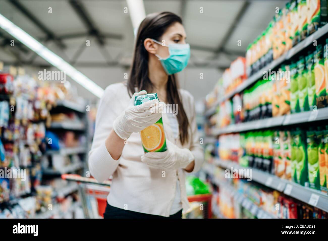 Fonte naturale di vitamine e minerals.Orange Juice.Vitamin C.Woman indossare maschera di acquisto in supermarket.Woman preparazione per il paddem virus patogeno Foto Stock