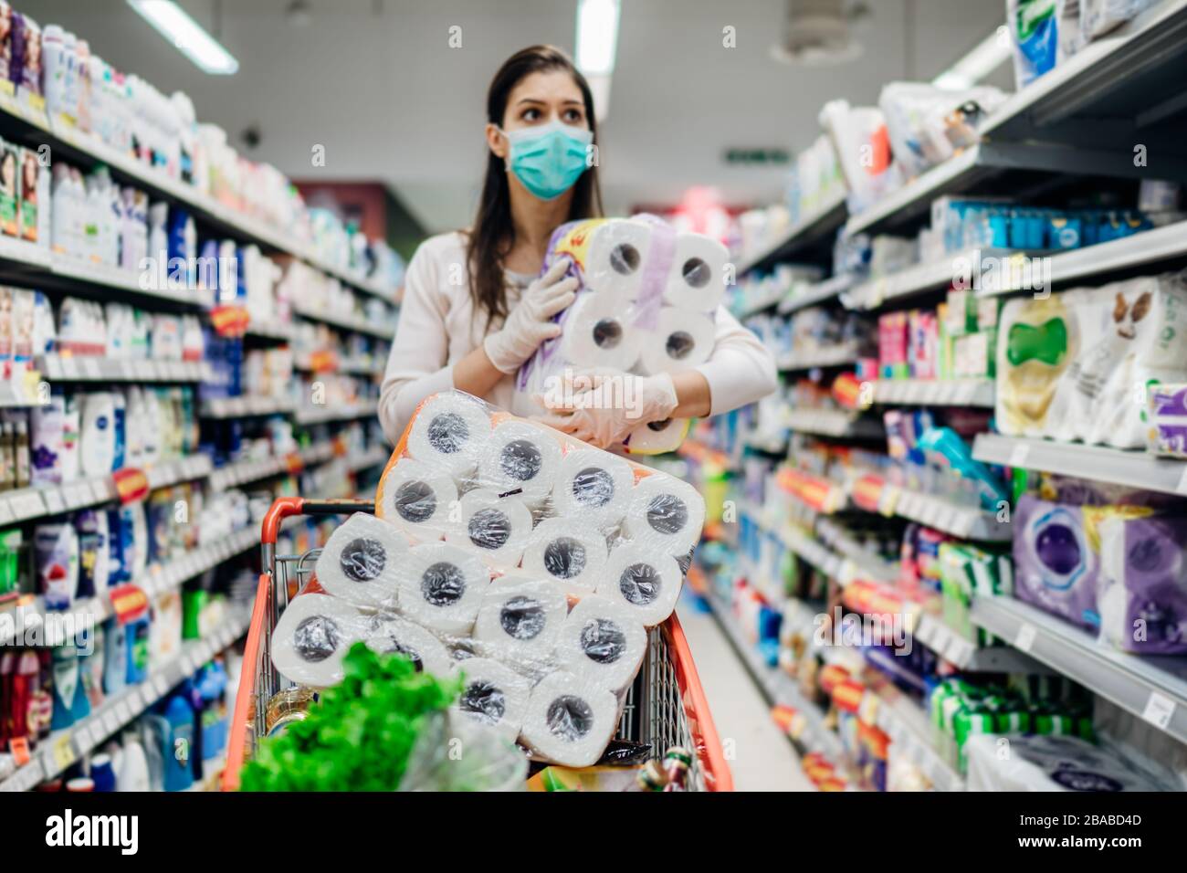 Carta da toilette sharage.Woman con maschera igienica shopping per i rifornimenti di carta da toilette a causa di panico acquisto e di prodotti di ostaggio durante epidemia di virus o Foto Stock