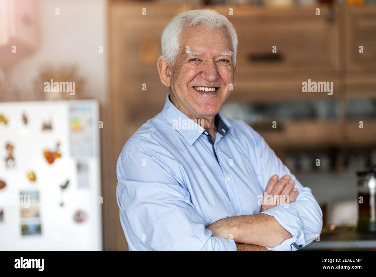 Uomo anziano sorridente in casa sua Foto Stock