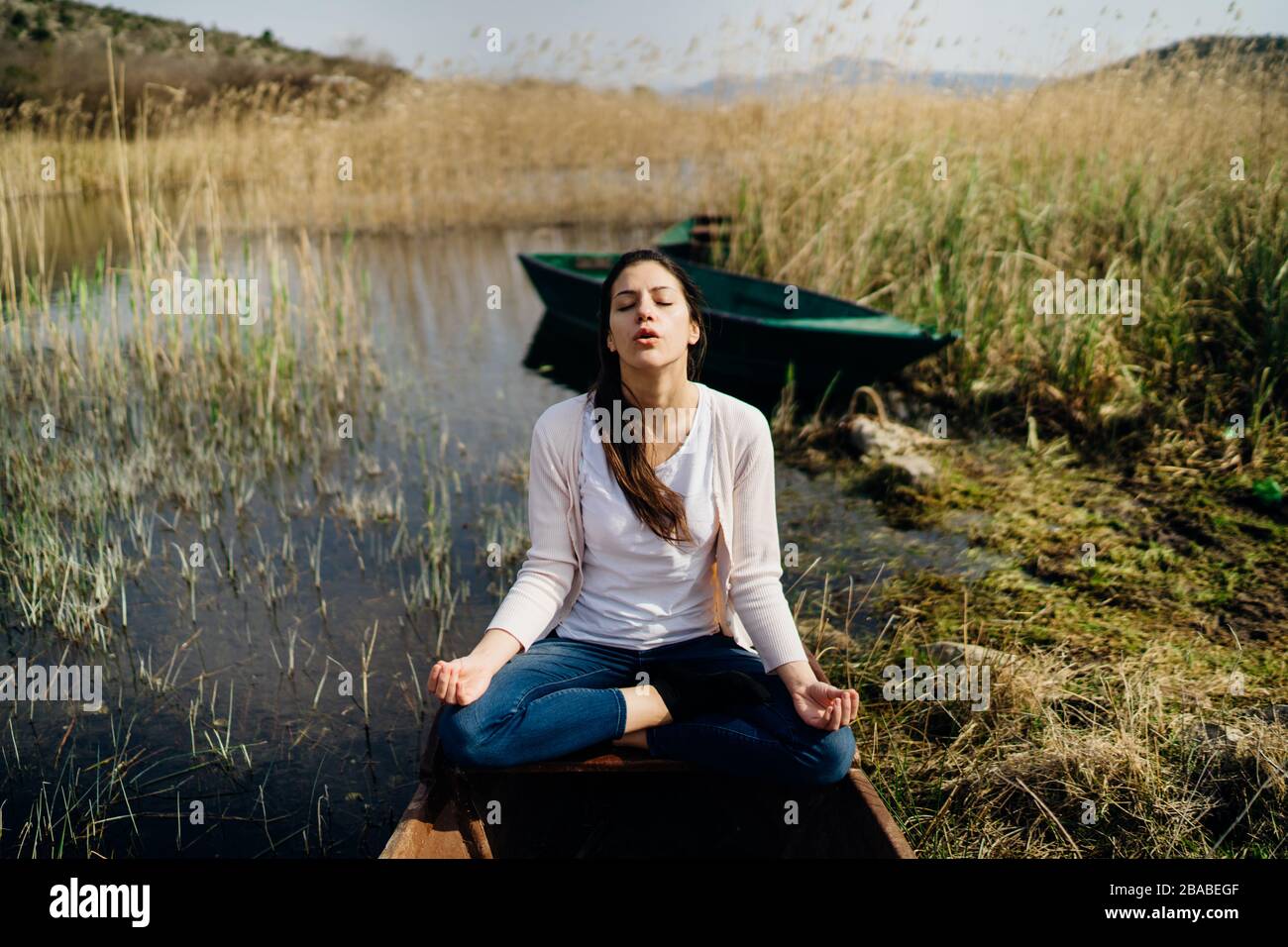 Donna meditando in natura.fuga da stressante reality.memore donna praticante meditation.Breathing technique.Mental state issues menagement. Foto Stock