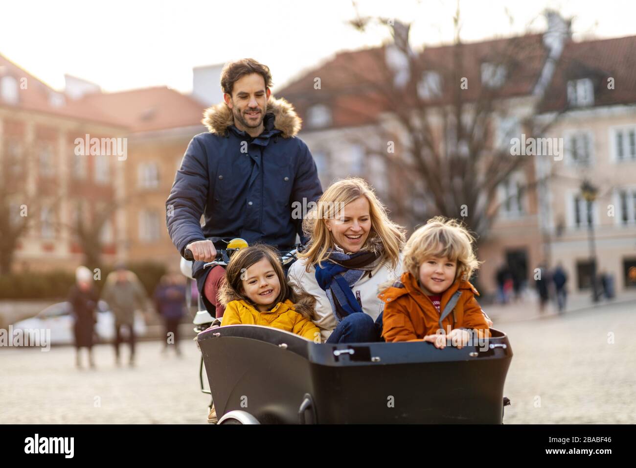 Giovane famiglia a cavallo in bicicletta da carico insieme Foto Stock