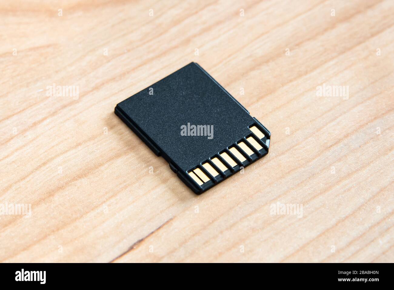 Una scheda di memoria SD su una superficie in legno. Foto Stock