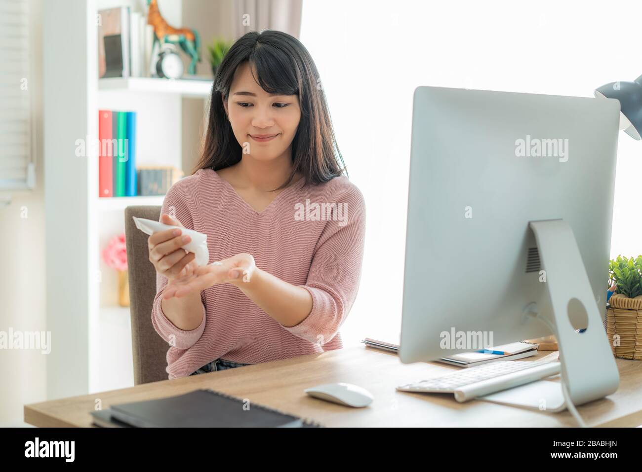 Donna asiatica che usa lozione o moisturize come mano della loro vita quotidiana per la pelle di protezione per diventare asciutta ed irritata dopo l'uso del gel antisettico dell'alcool Foto Stock