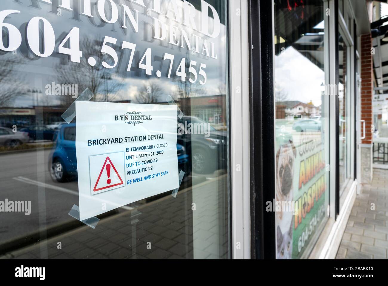 Surrey, Canada - 25 marzo 2020: Cartello sulla porta anteriore dell'ufficio dentale che annuncia la chiusura durante la pandemia di Coronavirus Foto Stock