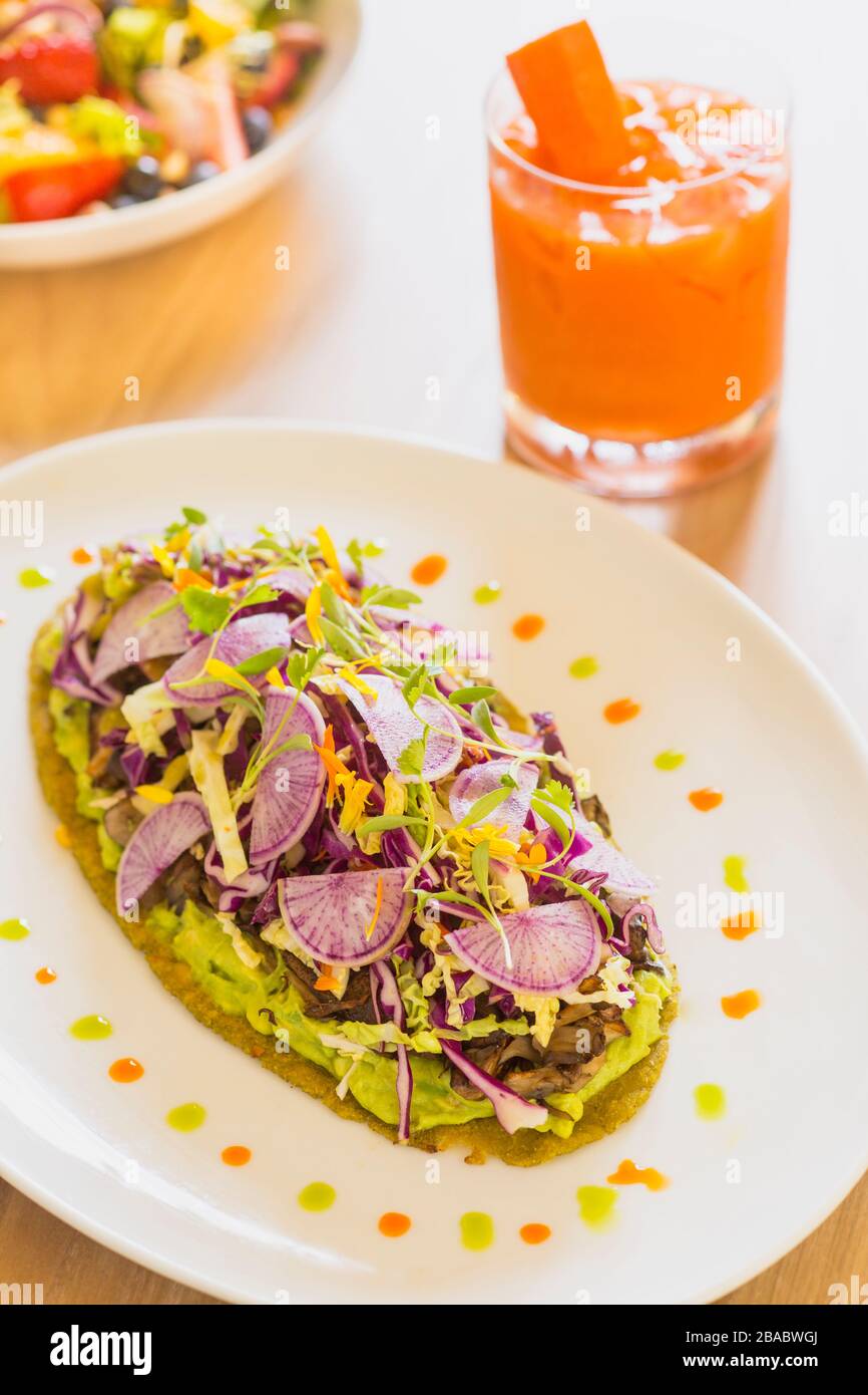 tostada di funghi selvatici, insalata e un cocktail di carote Foto Stock