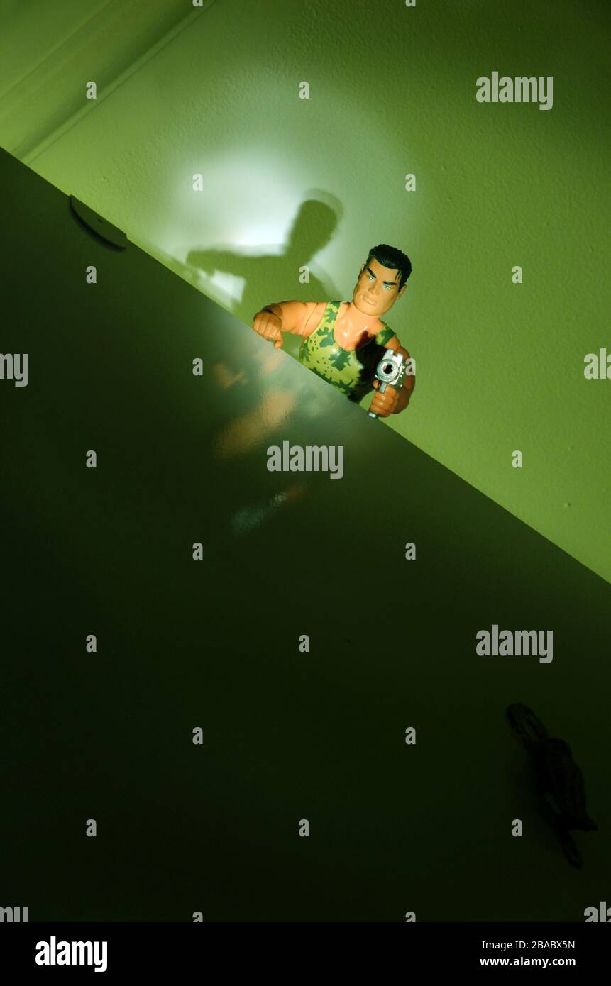 bambola da uomo d'azione con pistola vista dal basso in condizioni di scarsa illuminazione Foto Stock