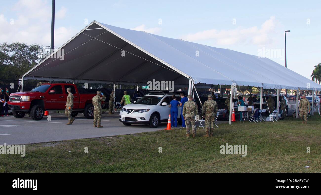 I membri della Guardia Nazionale della Florida dirigono i cittadini a un sito di prova basato sulla comunità COVID-19 presso il C. B. Smith Park 21 marzo 2020 a Pembroke Pines, Florida. Foto Stock