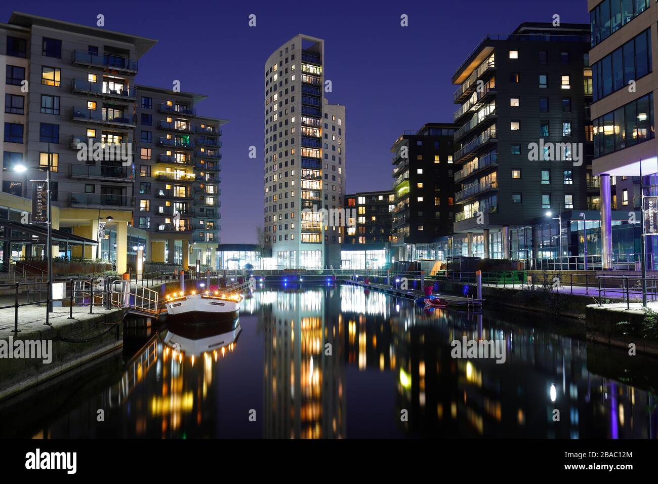 Riflessioni di appartamenti nel fiume Aire a Leeds Dock Foto Stock