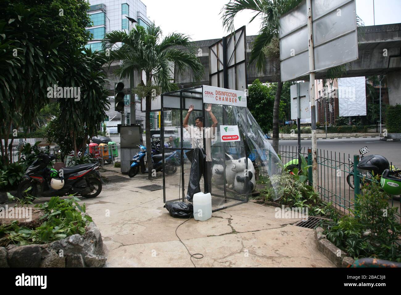 Giacarta, Indonesia. 25 Marzo 2020. I residenti che saranno attivi in luoghi pubblici, utilizzano la camera di disinfezione di Blok M, Giacarta Sud, Indonesia. In questa camera di sterilizzazione tutto il corpo della persona verrà spruzzato con liquido disinfettante. Questo liquido disinfettante ha la funzione di uccidere il virus della corona che si attacca ai vestiti o al corpo della persona, per anticipare la diffusione del virus della corona (COVID-19) negli spazi pubblici. (Foto di Kuncoro Widyo Rumpoko/Pacific Press) Credit: Pacific Press Agency/Alamy Live News Foto Stock