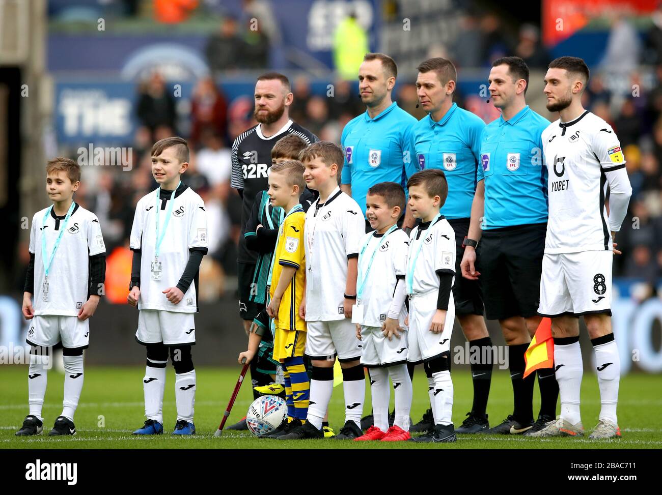 Derby County Captain Wayne Rooney (a sinistra) e Swansea City Captain Matt Grimes posa per una foto con i quattro ufficiali e le mascotte prima dell'inizio della partita Foto Stock