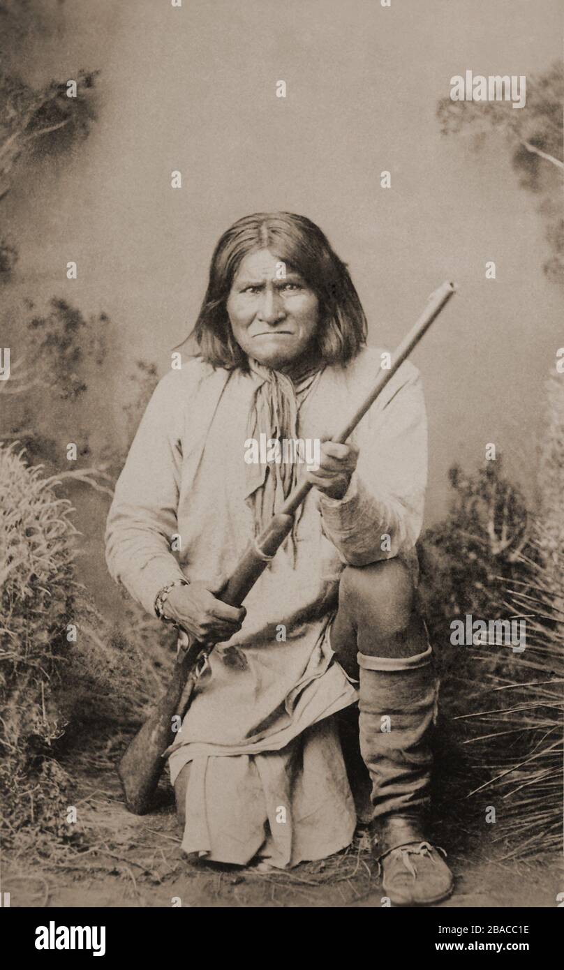 Geronimo, il grande capo di guerra di Chiricahua Apache, inginocchiato con un fucile, 1887. Fotografia di ben Wittick. Dopo il 1886 Geronimo rimase prigioniero federale custodito fino alla fine della sua vita. Ogni volta che lasciò il suo luogo di internamento, fu accompagnato da una guardia, anche quando si esibì presso i Wild West Shows (BSLOC 2019 9 132) Foto Stock