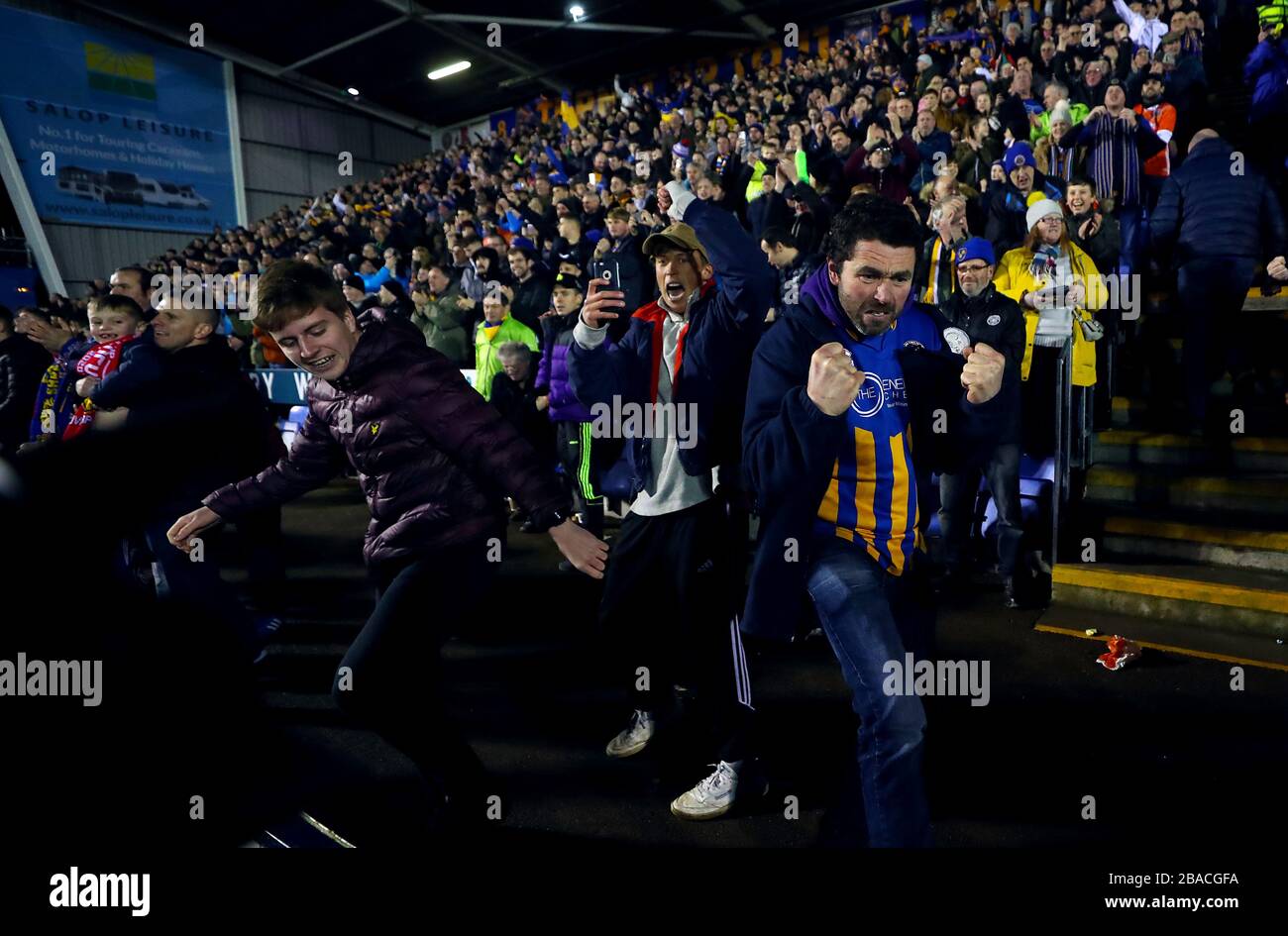 I fan della città di Shrewsbury festeggiano il primo goal dei loro schieramenti Foto Stock