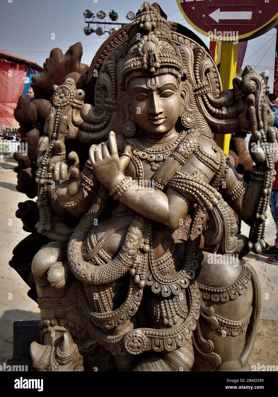 Impressionante statua del Signore Krishna scolpita in un unico blocco di legno in mostra alla fiera dell'artigianato surajkund, India Foto Stock
