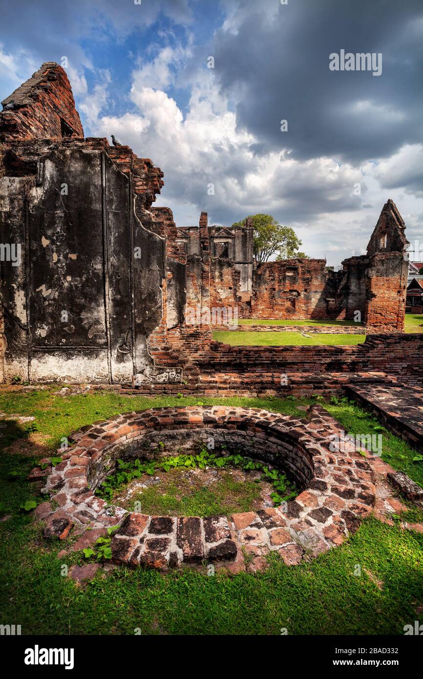 Antiche pareti in rovina e ben di tempio in Lopburi al Cielo di tramonto, Thailandia Foto Stock