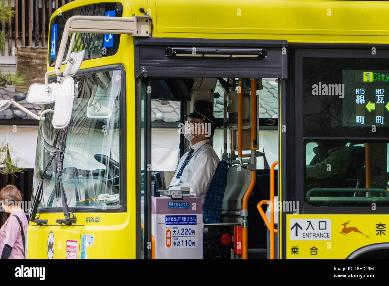 Un autobus giallo della linea circolare della città di Nara che aspetta ad una fermata di autobus a Nara Park, Nara, Giappone. Foto Stock