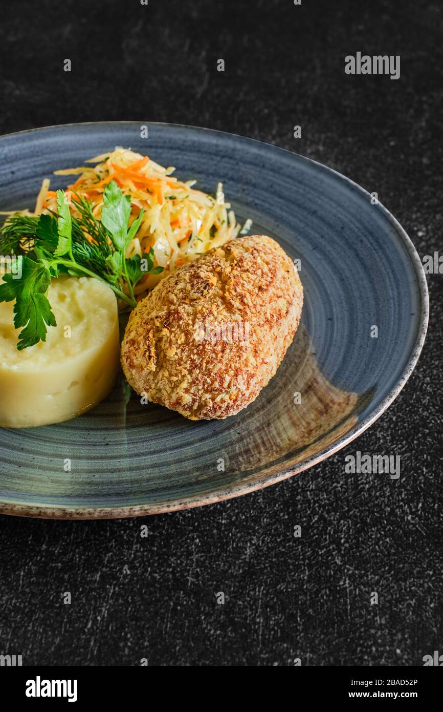 Tradizionale cotoletta di Kiev con purè di patate e cavolo sottaceto Foto Stock