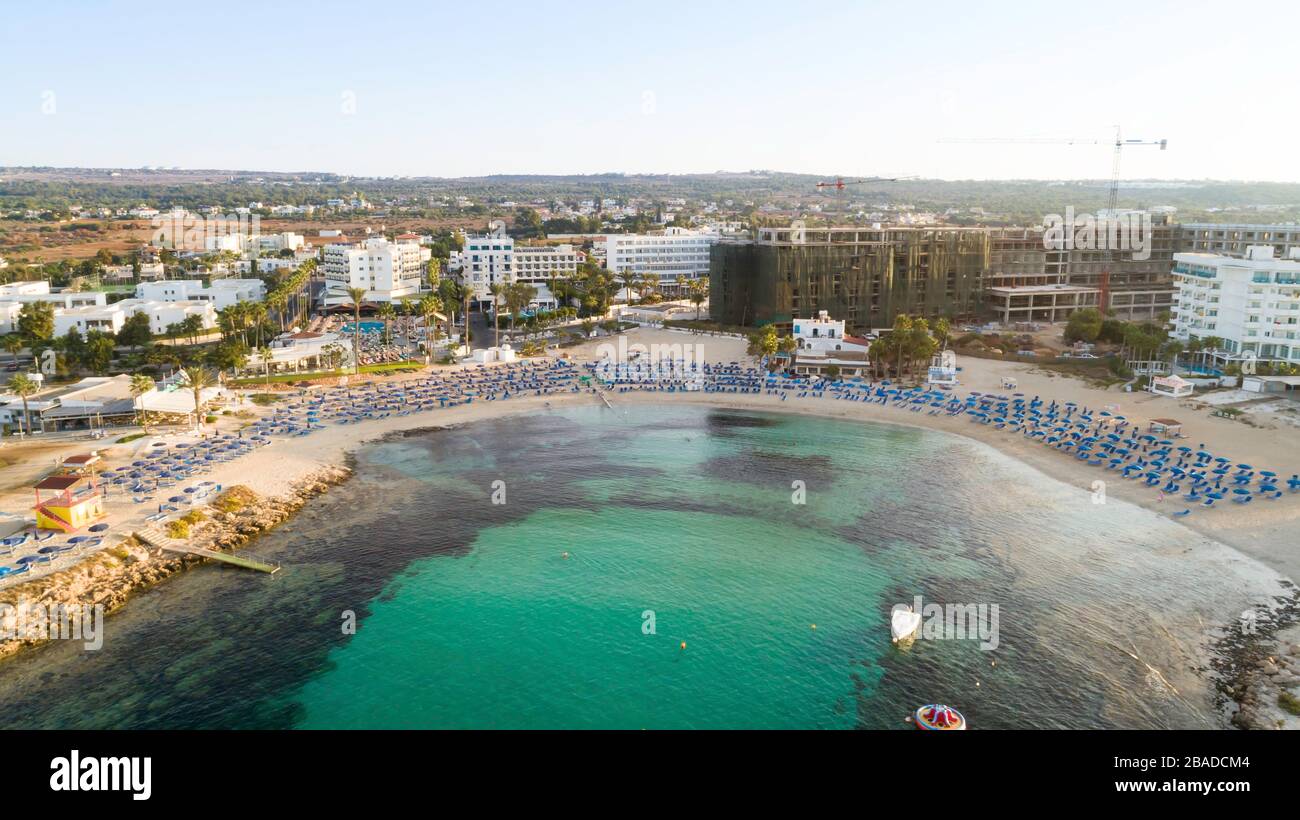 Vista aerea dall'alto della spiaggia di Vathia Gonia, Ayia Napa, Famagosta, Cipro. L'attrazione turistica punto di riferimento baia rocciosa all'alba con sabbia dorata, sole Foto Stock