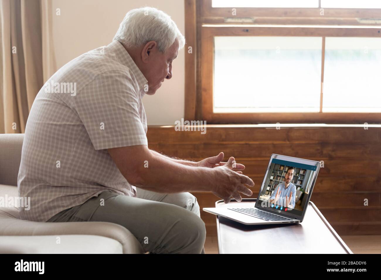 Uomo anziano maturo in videochiamata con figlio. Foto Stock