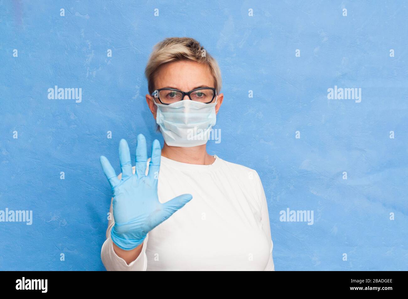 L'infermiere mostra le misure di sicurezza per il virus, indossando una maschera sanitaria e guanti, avverte la gente circa la diffusione del coronavirus. Foto Stock