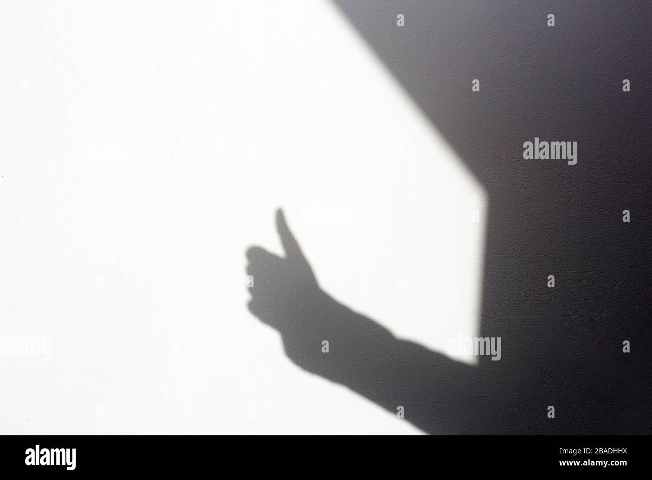 silhouette shadow mano facendo tumbi su parete bianca, isolato in casa Foto Stock