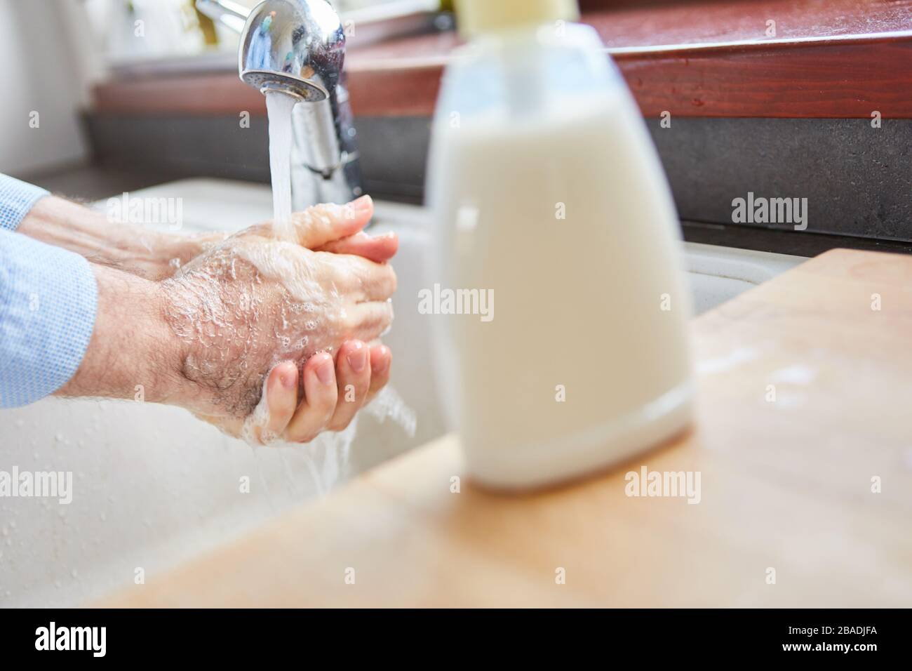 Mani di lavaggio senior mani con sapone liquido in bagno Foto Stock