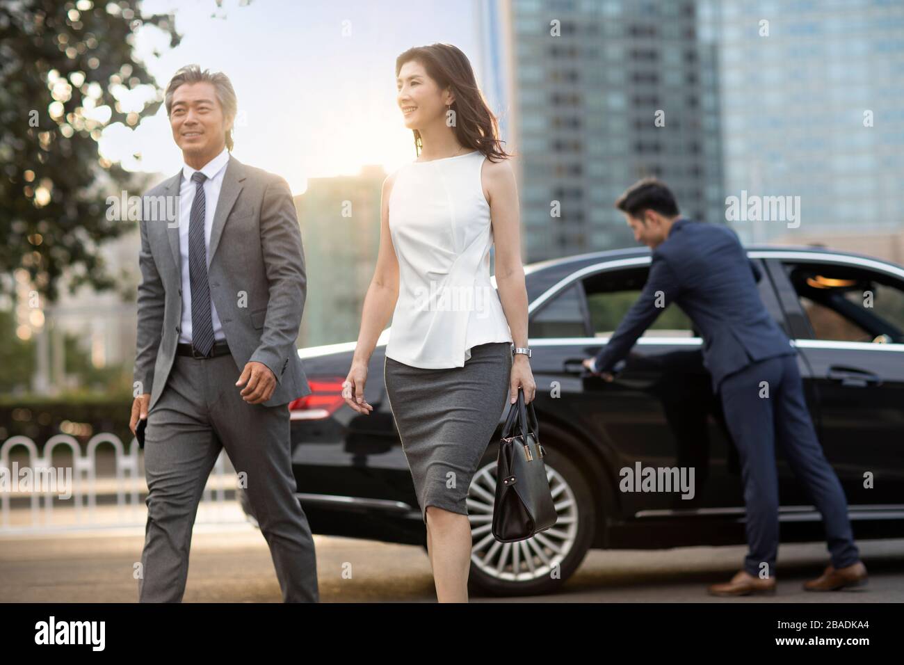 Gente d'affari cinese fiduciosa che esce dall'automobile Foto Stock