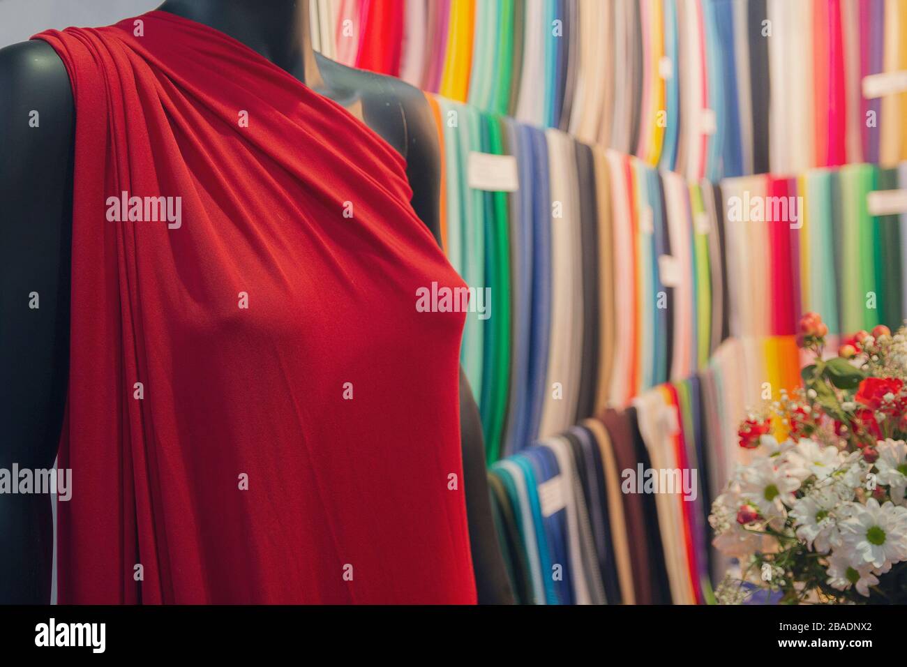 Indossa un abito in manichino e una scelta di tessuti multicolore in un negozio. Moda Foto Stock