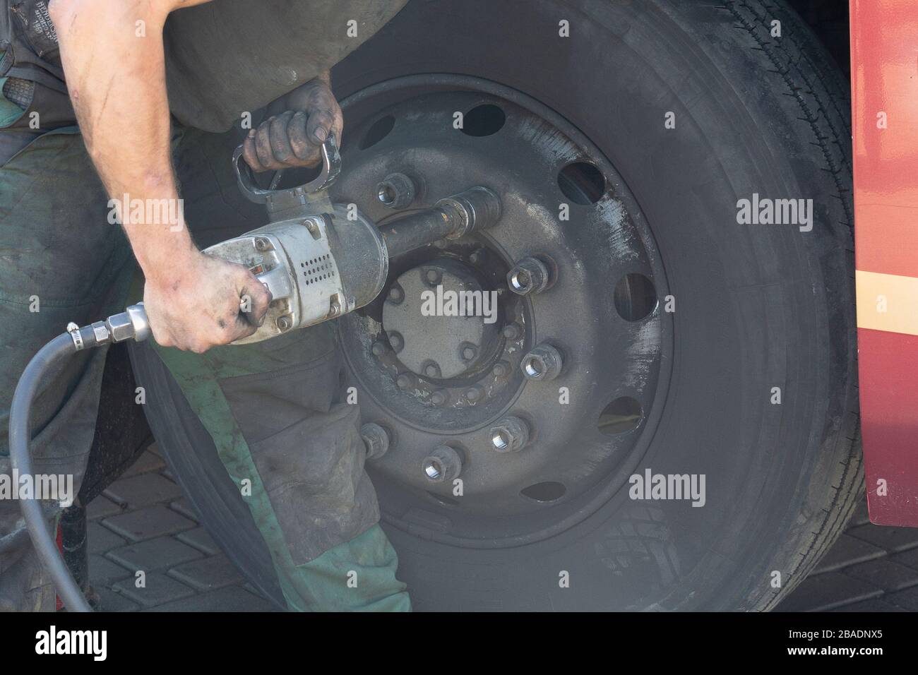 Il garage principale sviti i dadi sulla ruota rotta del bus. Foto Stock